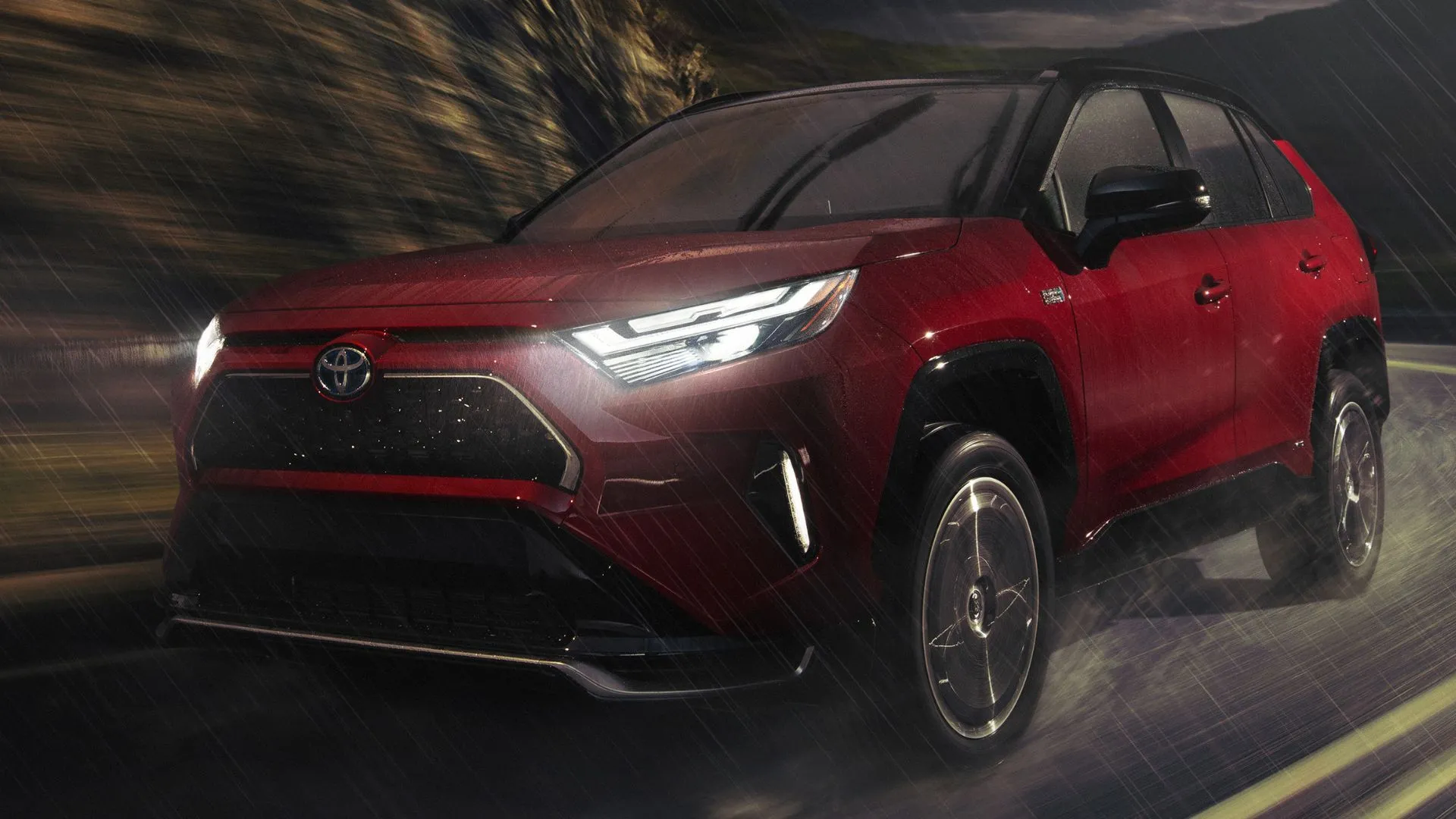 Toyota RAV4 Prime XSE 2024 màu đỏ lăn bánh mượt mà trên đường nông thôn giữa đêm mưa, minh chứng cho độ bền bỉ và đáng tin cậy của SUV Plug-in Hybrid