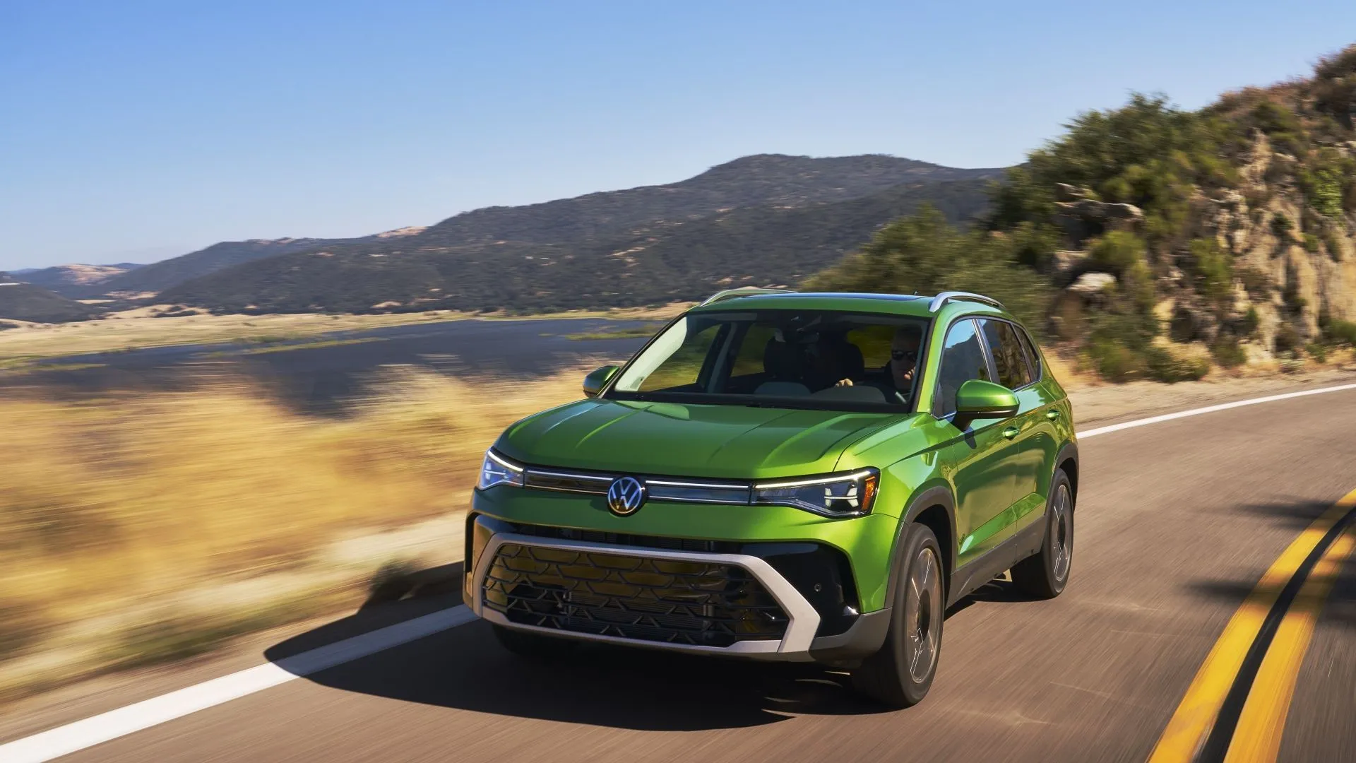 Volkswagen Taos 2025 màu xanh ngọc, ảnh chụp 3/4 phía trước, nhấn mạnh thiết kế độc đáo và không gian rộng rãi của mẫu crossover AWD.