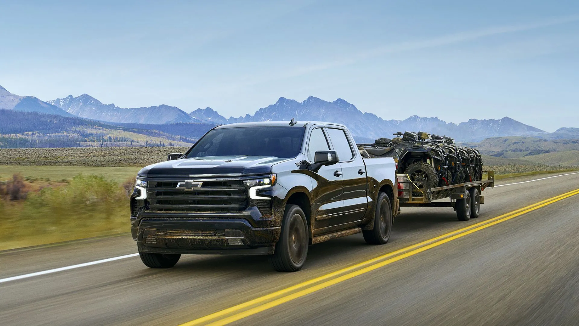 Xe bán tải Chevrolet Silverado 2025 kéo rơ-moóc trên đường nông thôn, cho thấy doanh số dẫn đầu của Chevrolet