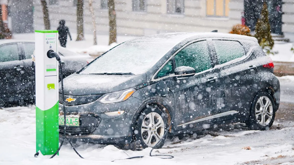Xe điện Chevrolet Bolt đang sạc tại trạm sạc trong điều kiện thời tiết tuyết rơi, biểu tượng của sự tiện lợi và phổ biến của xe điện.