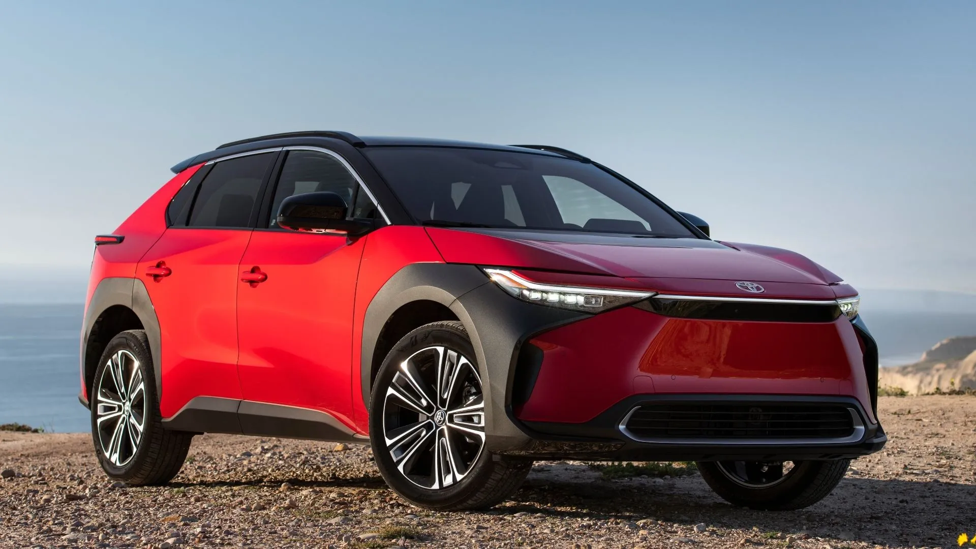 Xe điện Toyota bZ4X màu đỏ đỗ trên nền sỏi, thể hiện sự tăng trưởng đột phá của dòng EV.