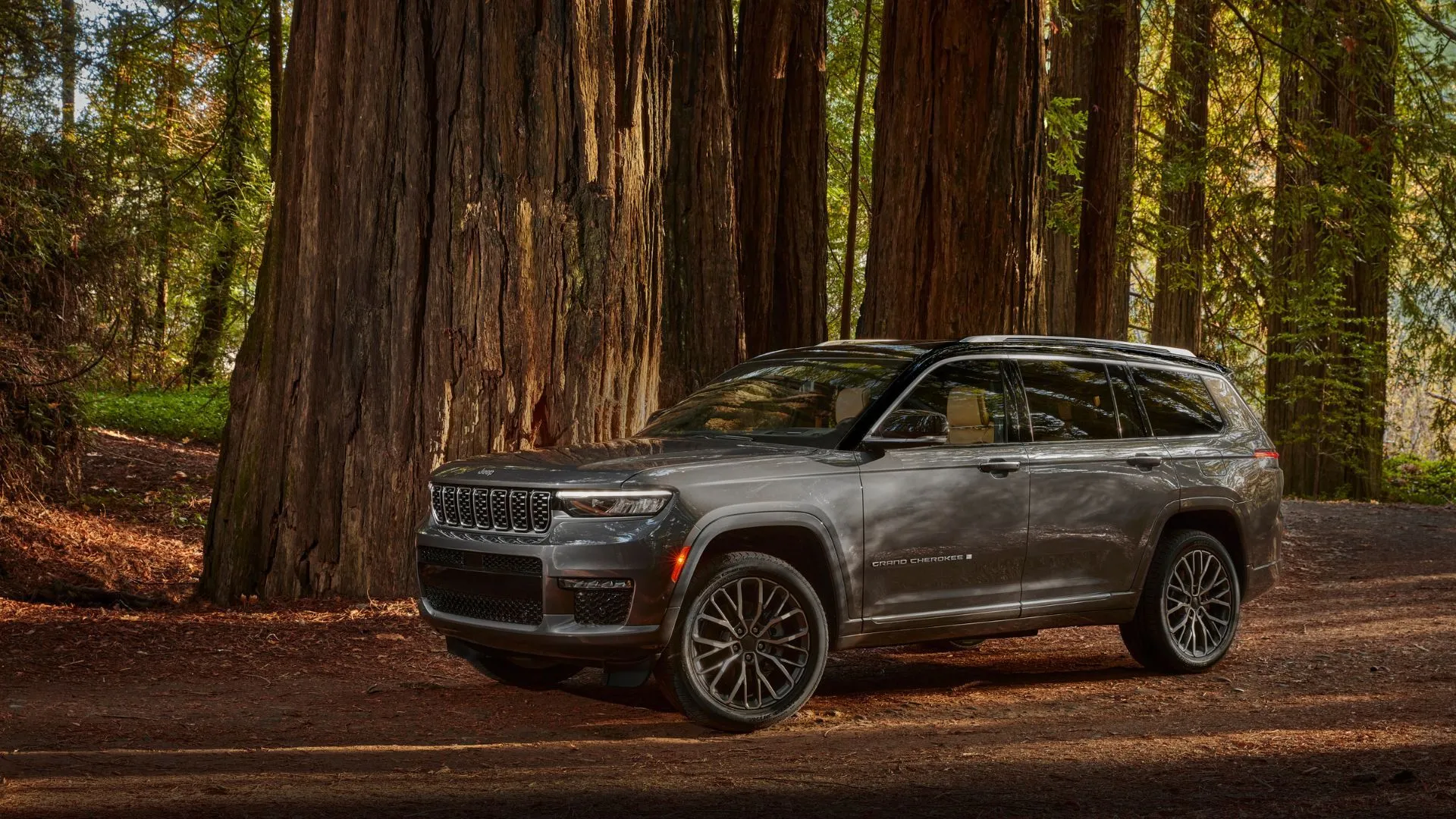 Xe Jeep Grand Cherokee L 2025 màu xám đỗ trong rừng, thể hiện khả năng off-road của SUV Jeep